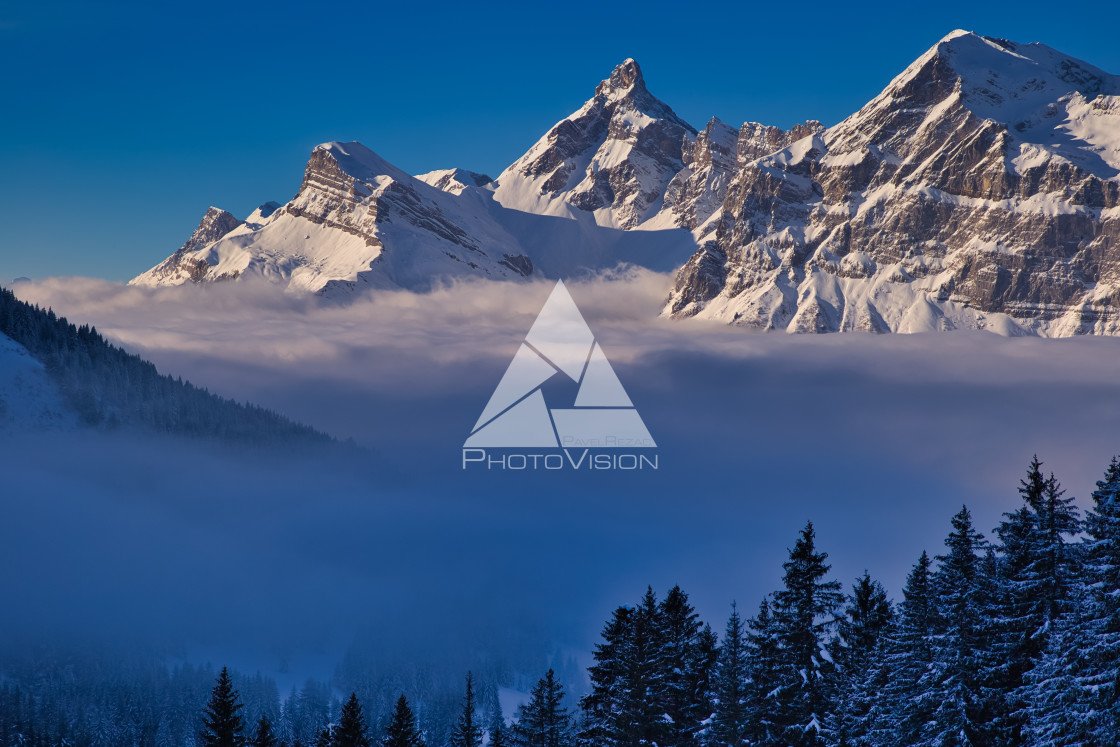 "Inversion in valley and illuminated mountain peaks" stock image