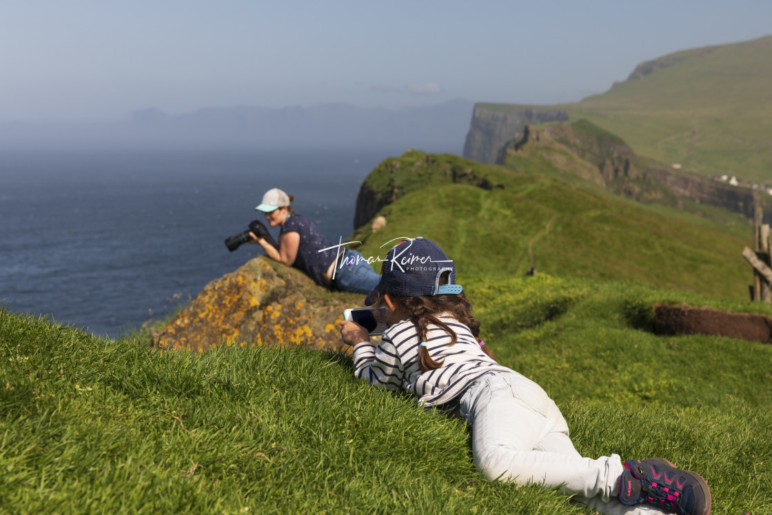 "Little girl relaxing in the grass with her phone" by Thomas Reimer - $12.70 "Little girl relaxing in the grass with her phone" stock image