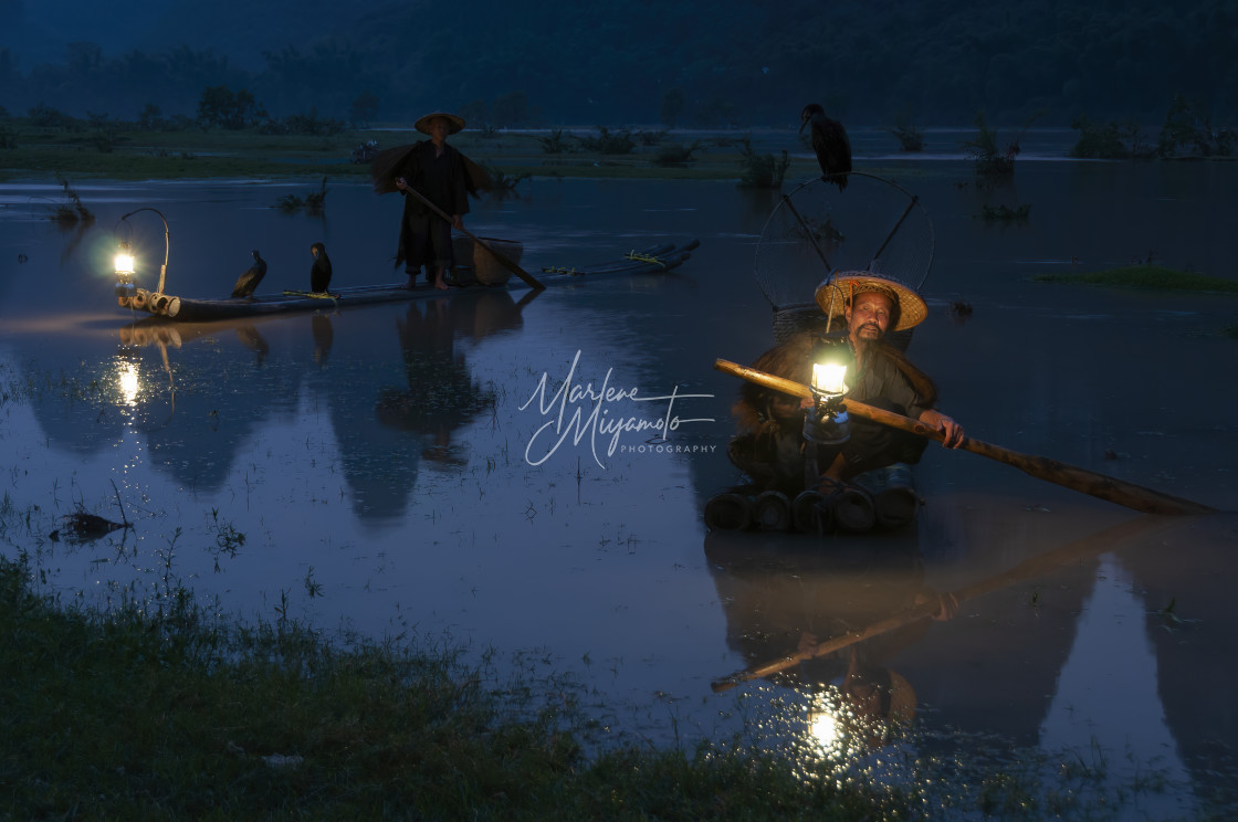 "Two Cormorant Fishermen Wait in the Dark with their Lanterns" stock image