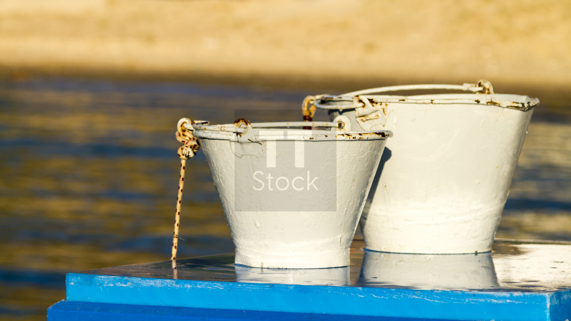 "White buckets on blue table" stock image