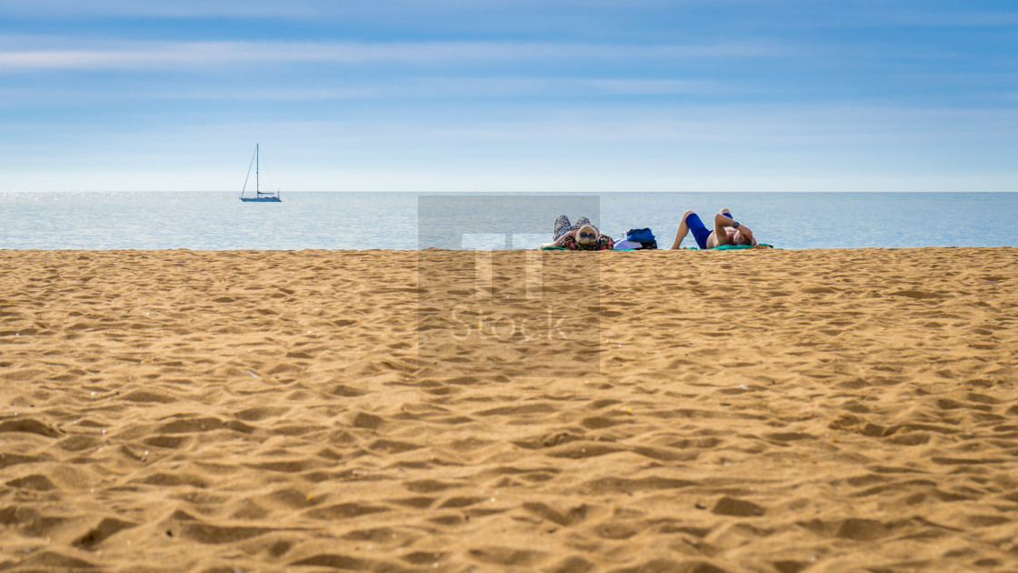 "Impressions Of Portugal - Couple lying on an empty beach" stock image