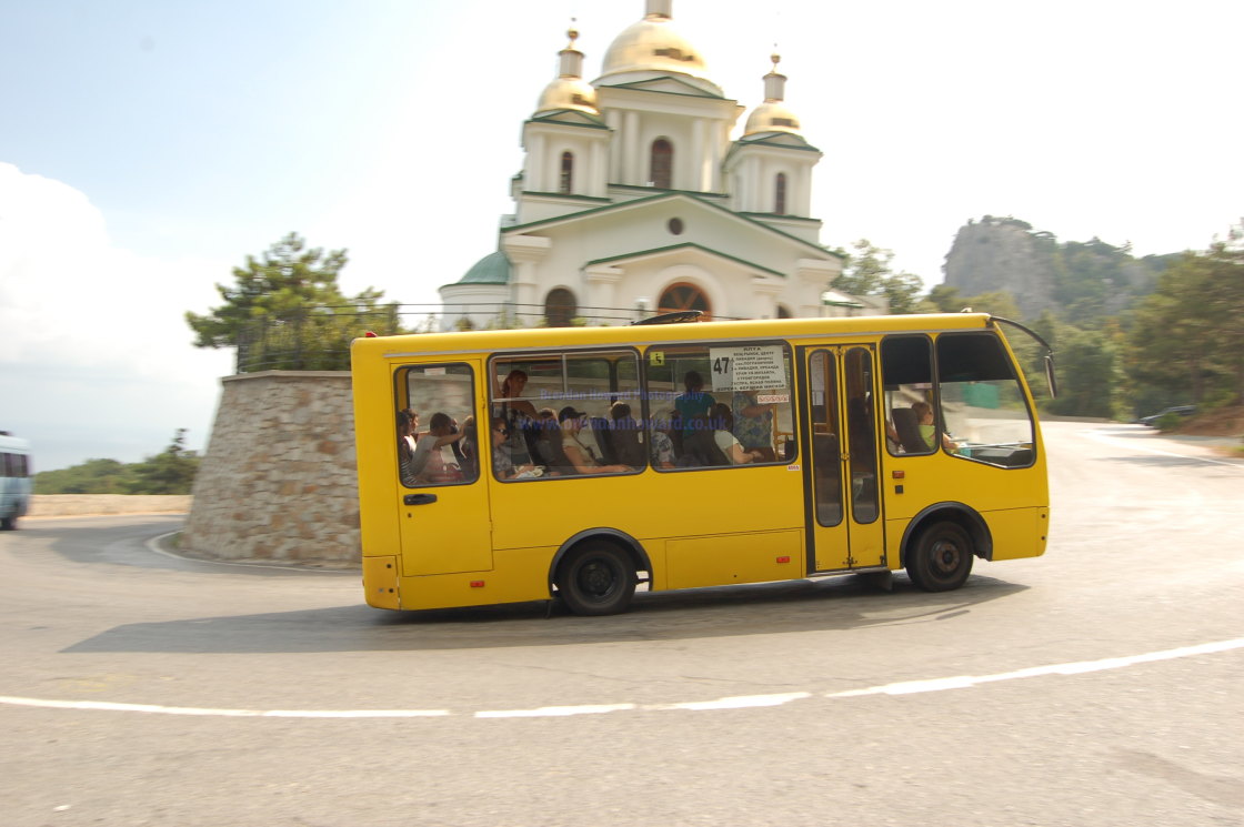 "Bus passing church on hill in Crimea, Ukraine" stock image