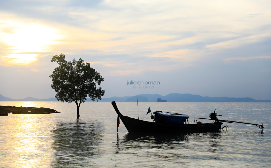 "Long tail boat at anchor at sunset in Thailand." stock image