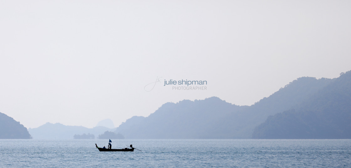 "Misty view with a long tail boat on the seas in Thailand." stock image