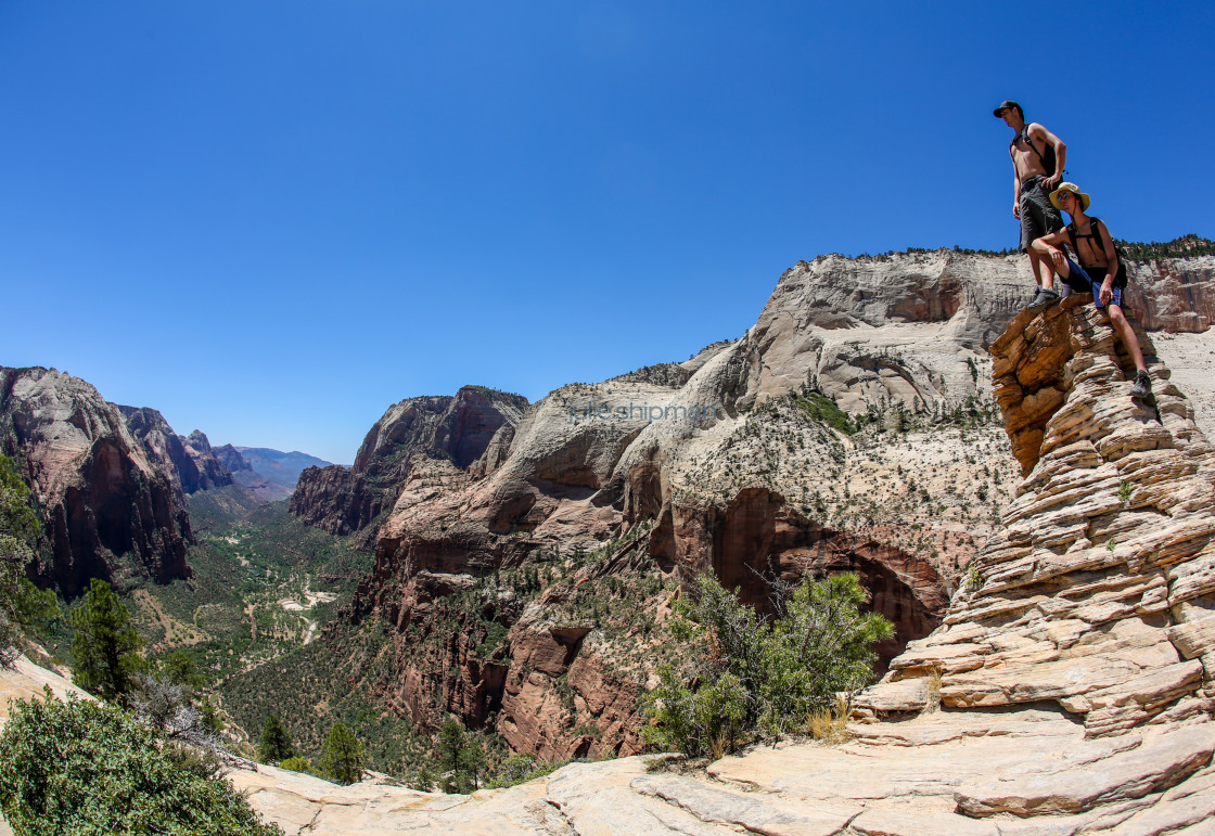 "Two men arrive at the top of Angels Landing, one of the best hikes and adventures in Zion National Park, Utah, USA." stock image