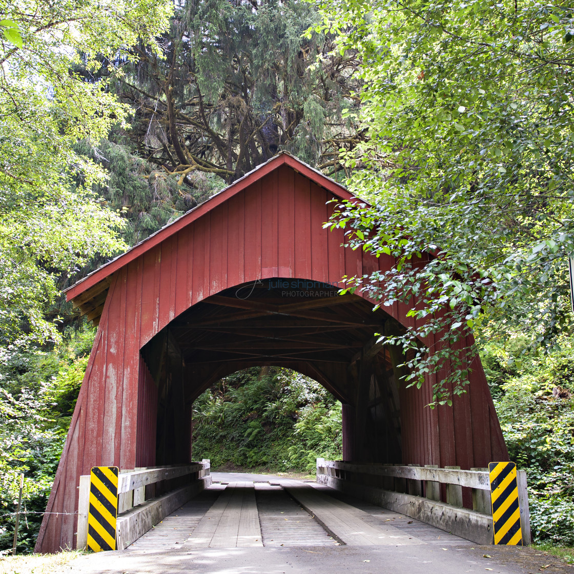 "The old wooden red covered bridge on a road in Oregon." stock image