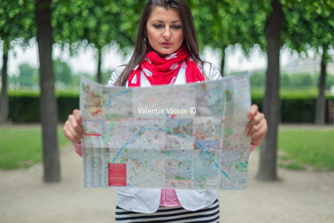 "Young woman looking on the map at the city park Paris, France" stock image