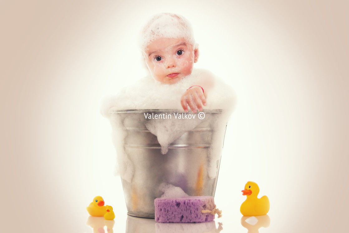 "Little baby on a bucket on white background" stock image