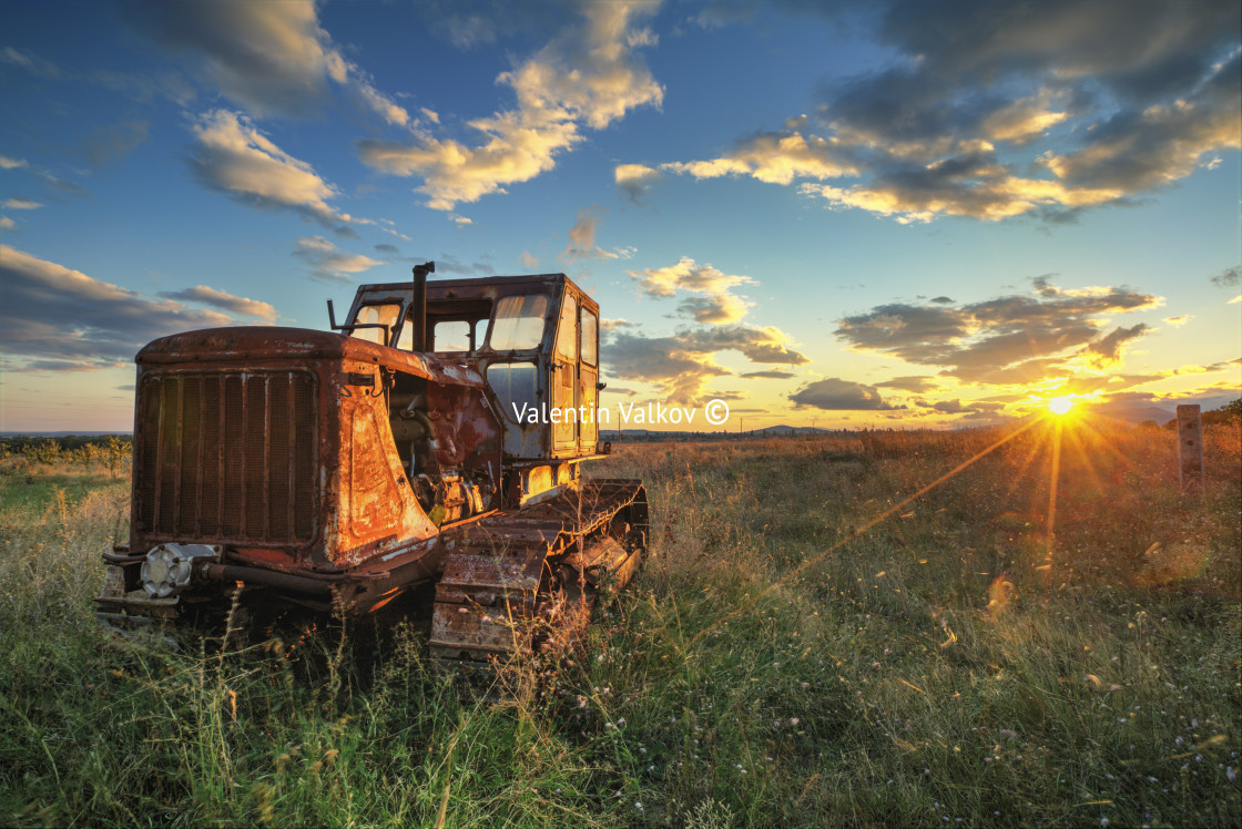 "Old rusty tractor in a field on sunset" stock image