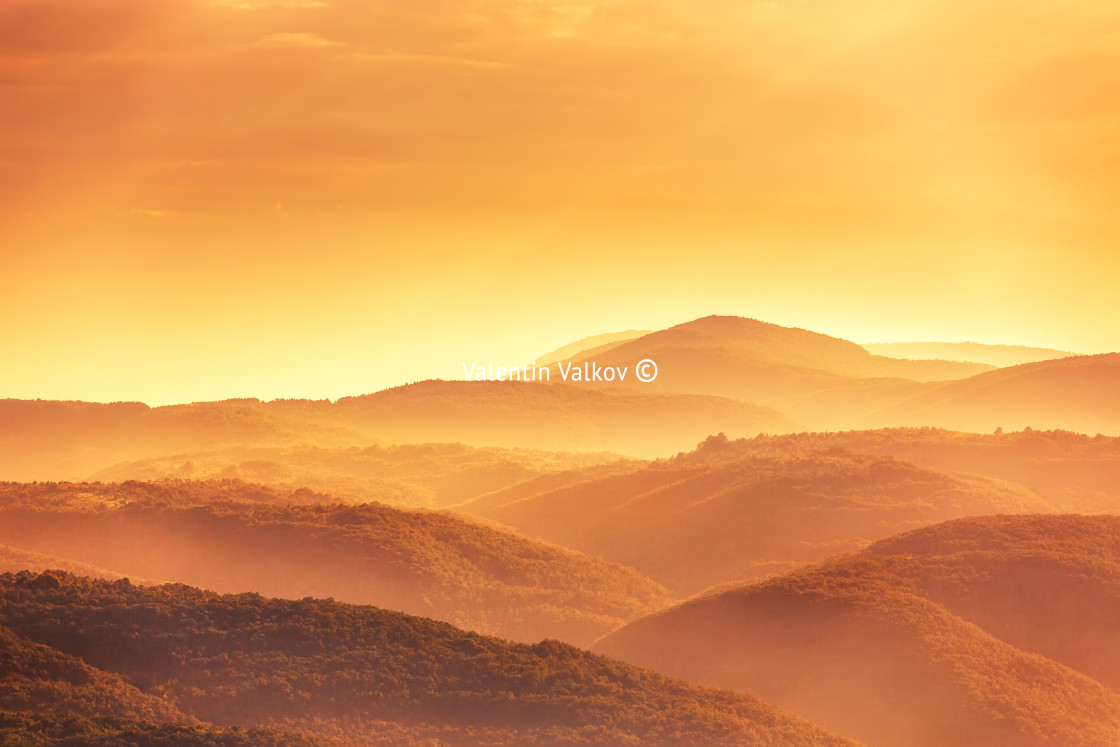 "View of a valley in a beautiful early morning with fog between hills" stock image