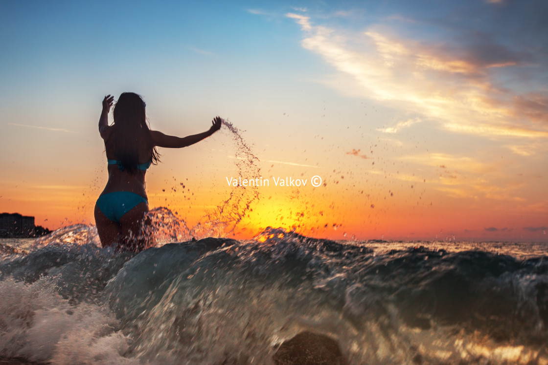 "Happy woman running in the sunset on the beach" stock image