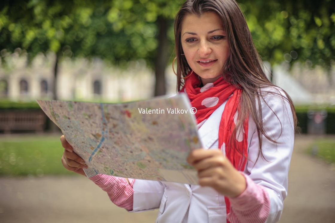 "Young woman looking on the map at the city park Paris, France" stock image