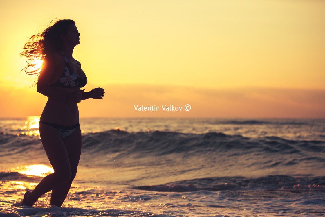 "Silhouette of carefree woman on the beach" stock image