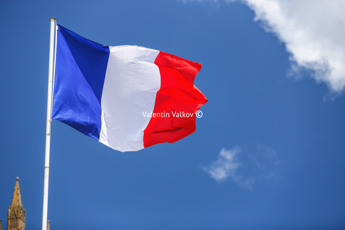 "French flag against blue cloudy sky." stock image