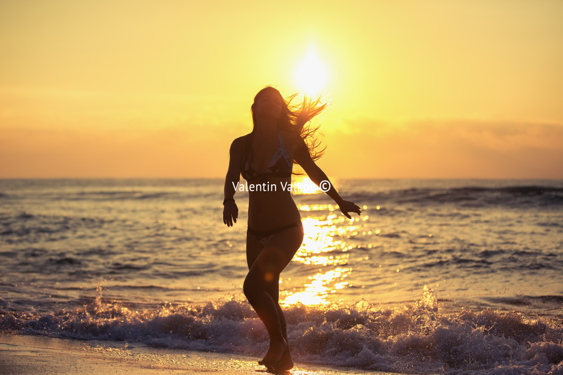 "Silhouette of carefree woman on the beach" stock image