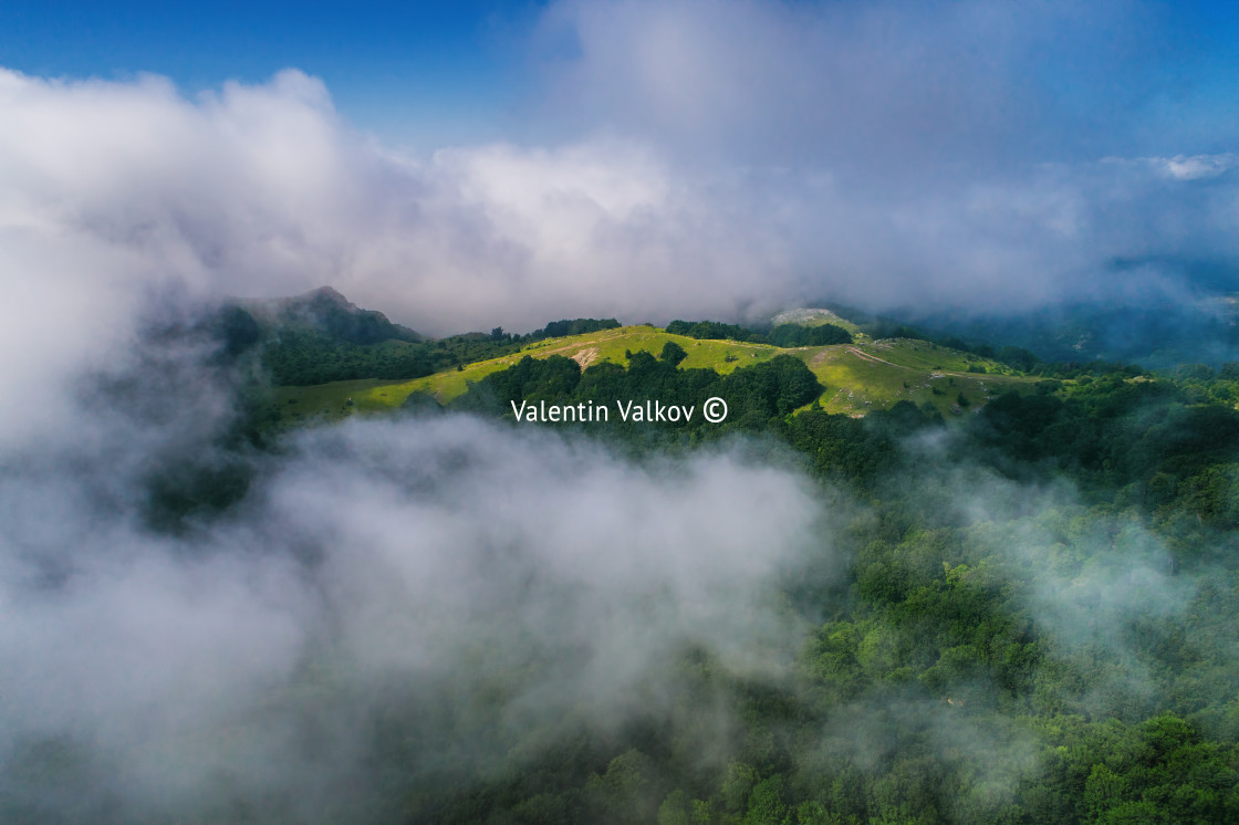 "Aerial view over the clouds and mountain peaks" stock image