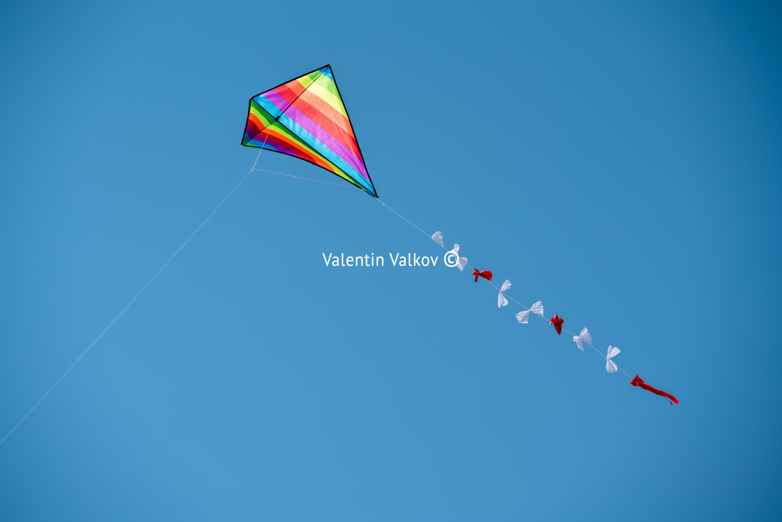 "Colorful kite flying against a blue sky" stock image