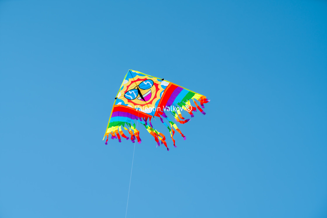 "Colorful kite flying against a blue sky" stock image