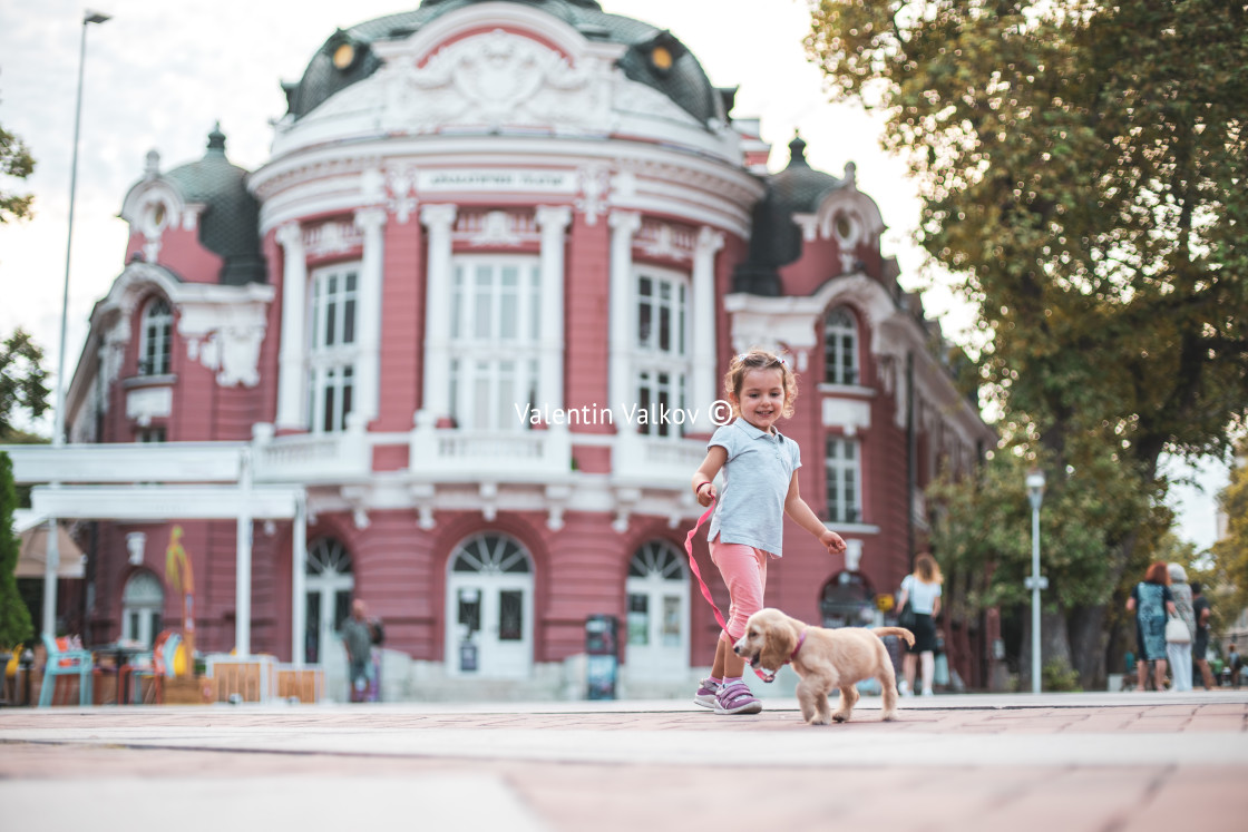 "Little kid walking her cocker spaniel, dog in town" stock image