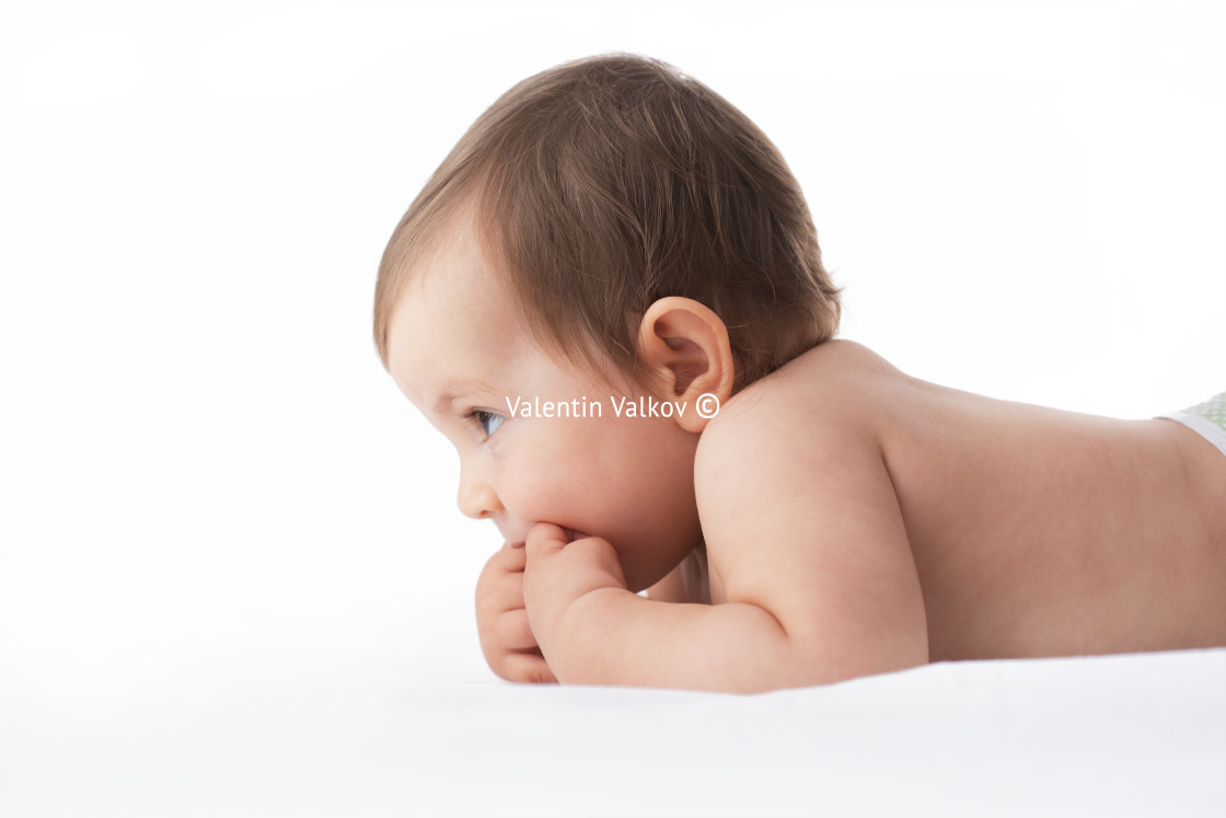 "Portrait of adorable baby girl lying naked on her stomach on sof" stock image