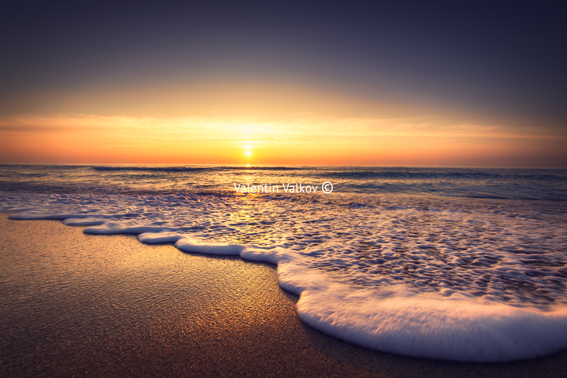 "Sunrise over the sea and beach. Waves washing the sand" stock image