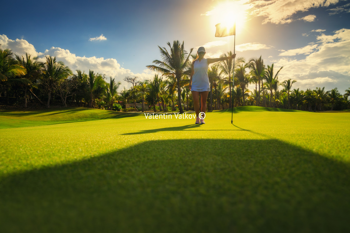 "Young woman golfer standing on tropical golf course, , lens flar" stock image