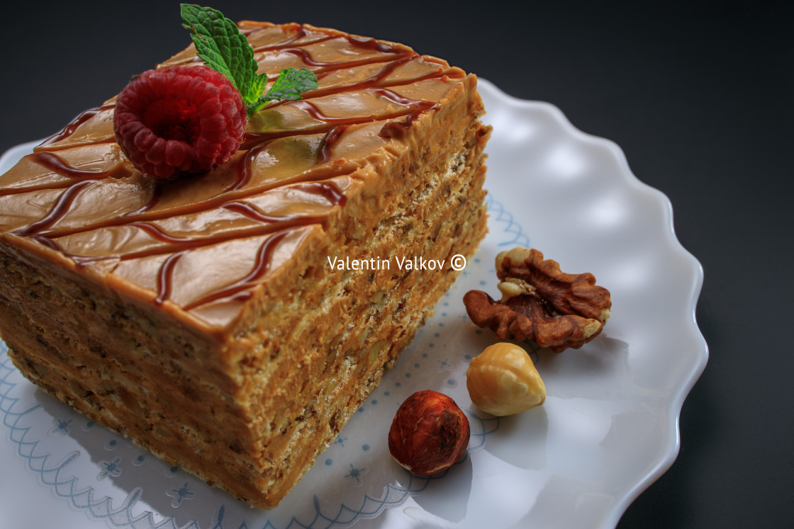 "Cake piece with nuts, chocolate, biscuits and caramel cream isol" stock image