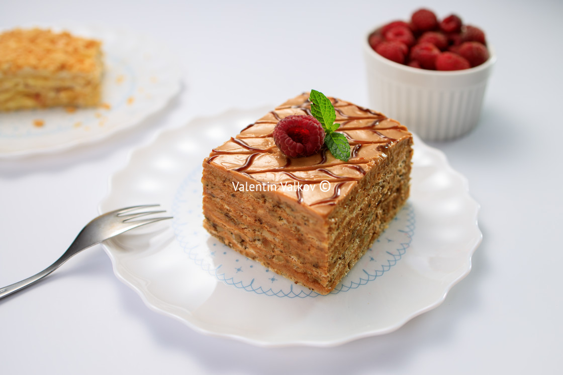 "Cake piece with nuts, chocolate, biscuits and caramel cream on w" stock image