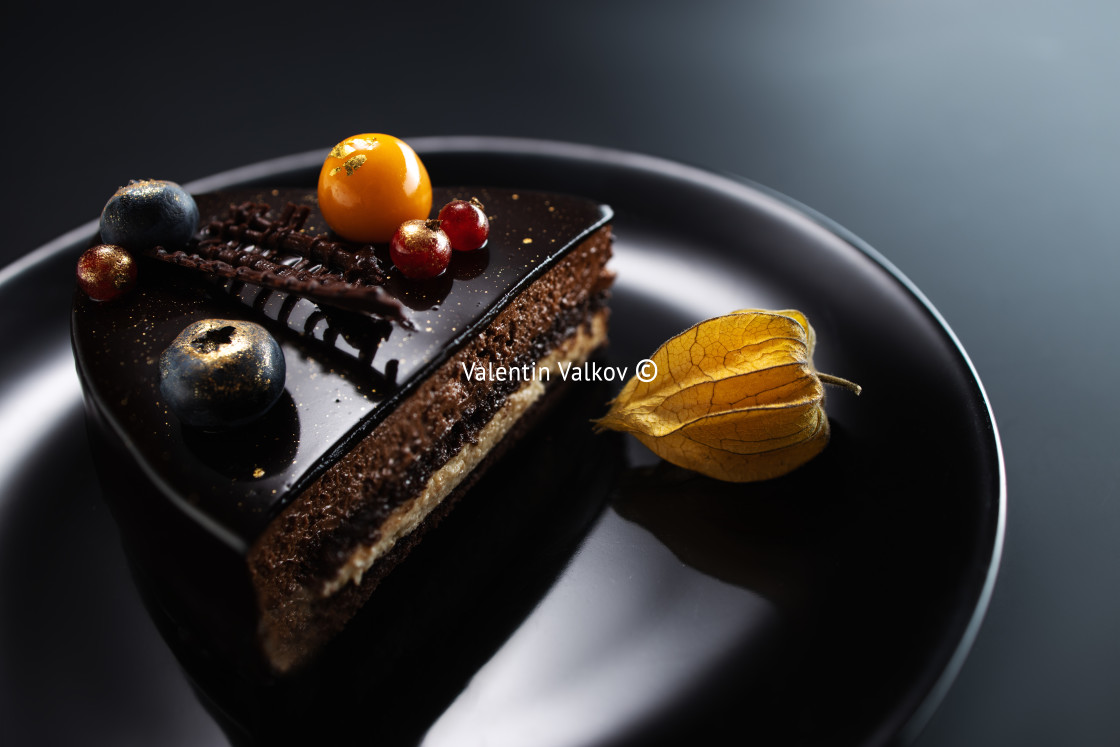 "Chocolate cake with decoration and fruits on black background" stock image