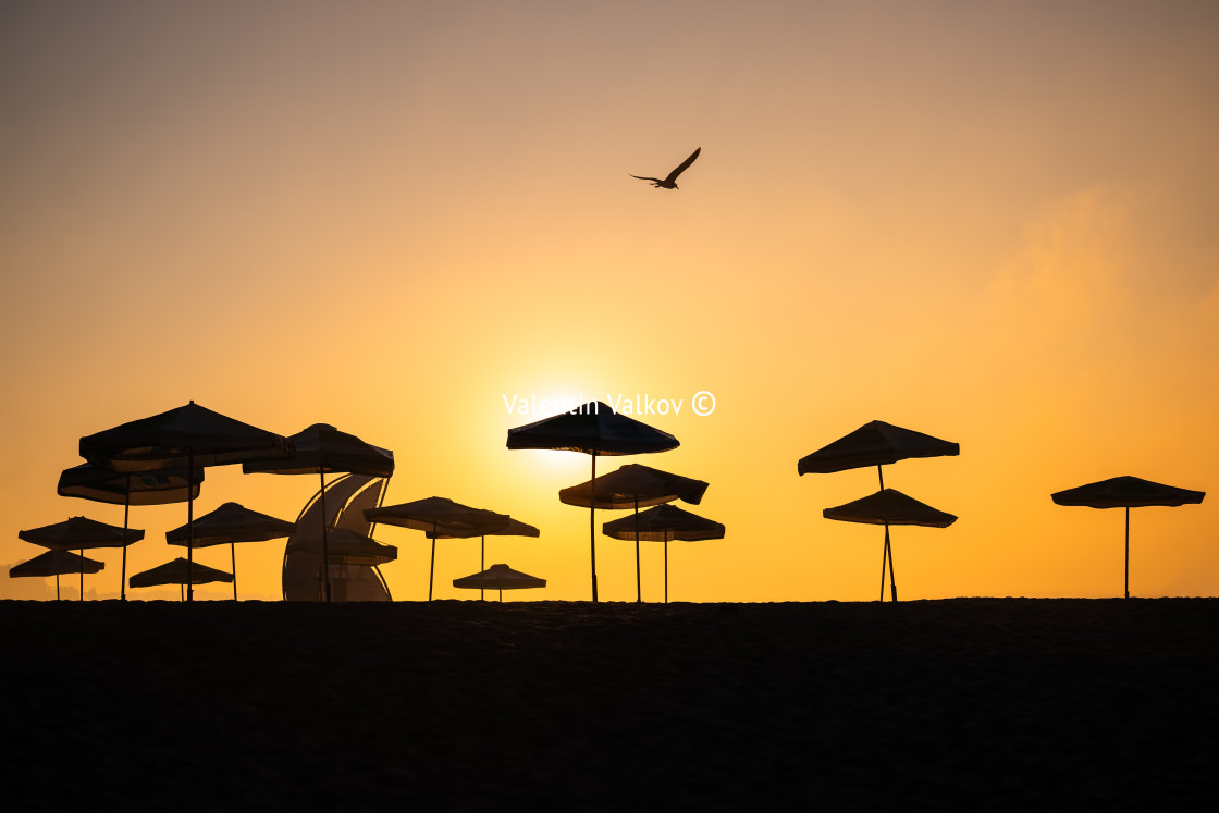 "Sunrise with sunshade and life guard station silhouette" stock image