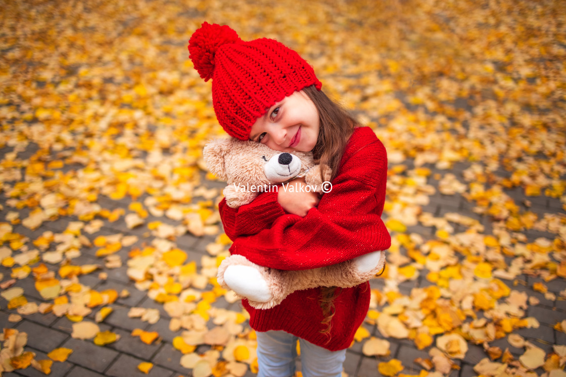 "Happy little girl playing with his teddy bear toy in autumnal pa" stock image