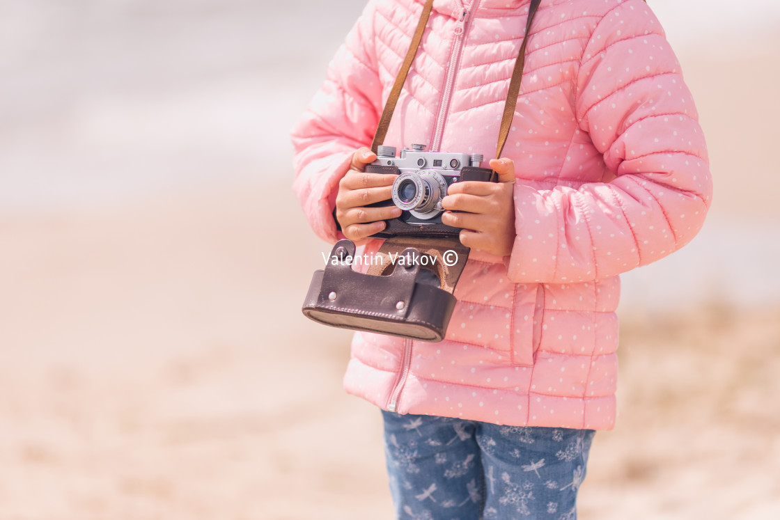 "Little girl with old vintage camera making photos of sea waves a" stock image