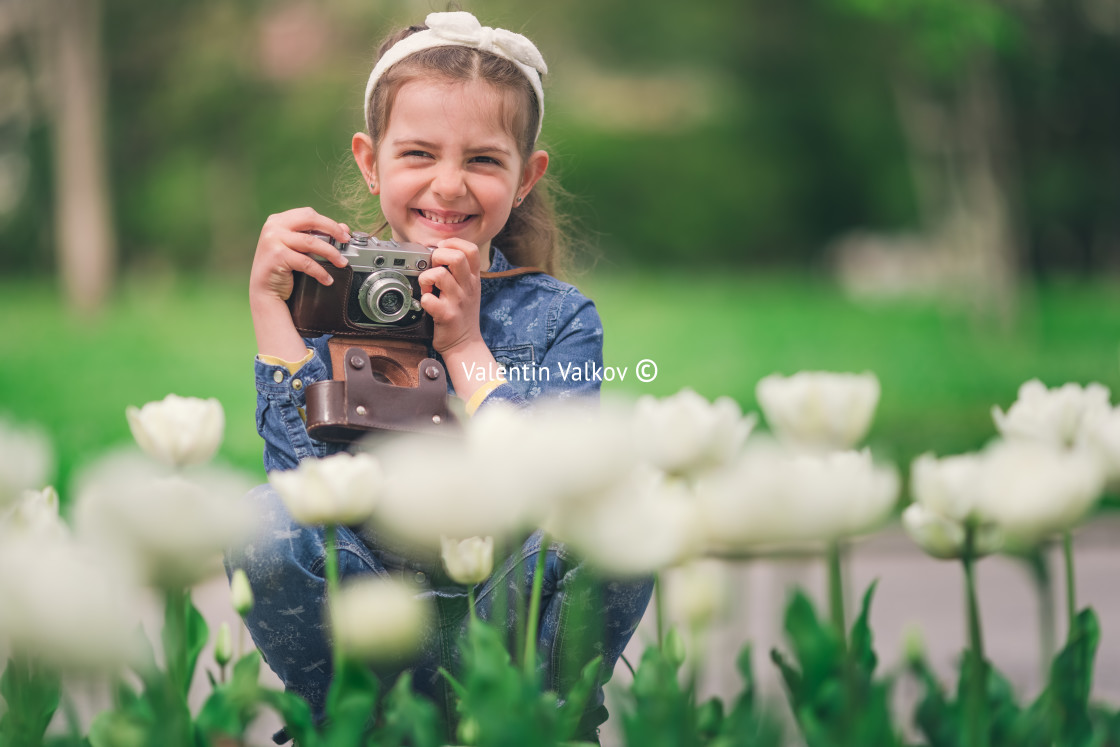 "Little girl with old vintage camera making photos of tulips in f" stock image