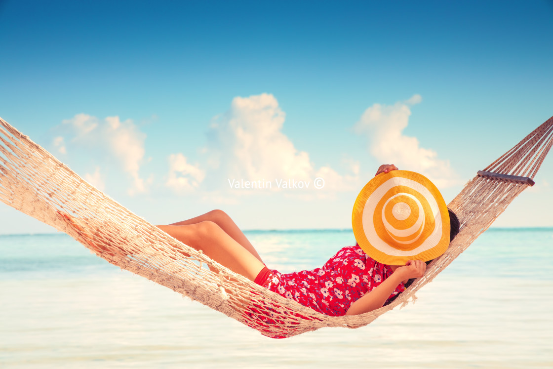 "Young girl resting in a hammock under tall palm trees, tropical" stock image