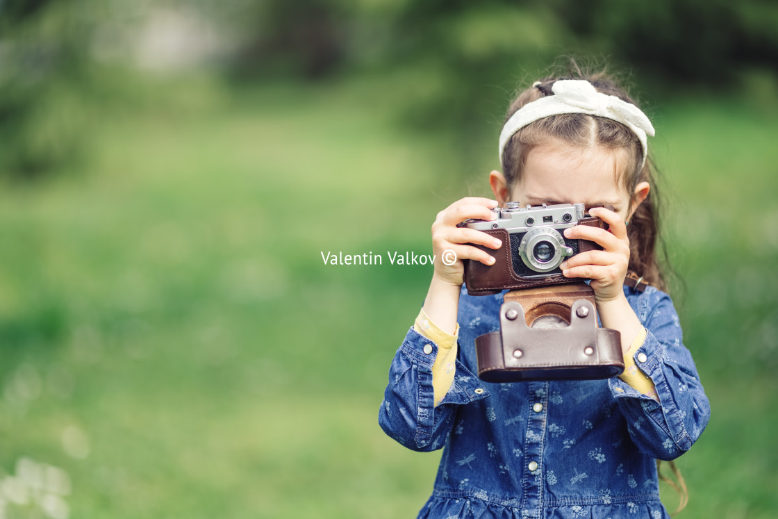 "Little girl with old vintage camera making photos of surrounding" stock image