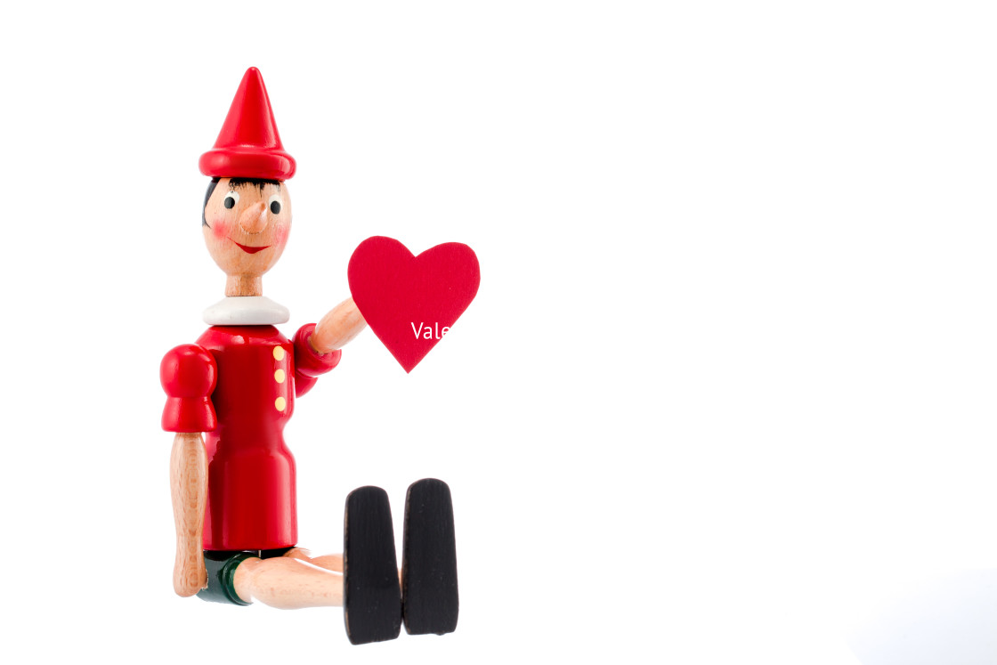 "Pinocchio toy statue with heart isolated on white" stock image