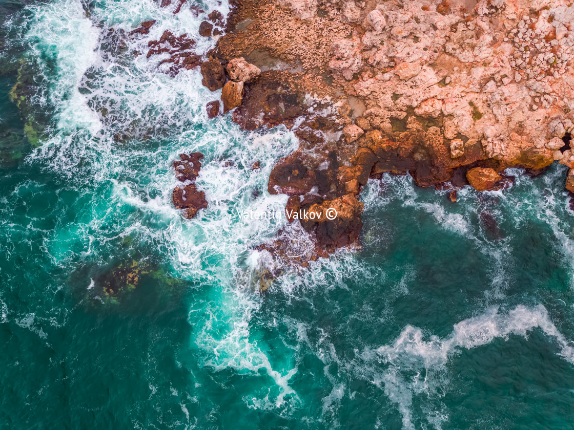 "Aerial view of rocky coastline and crashing waves" stock image