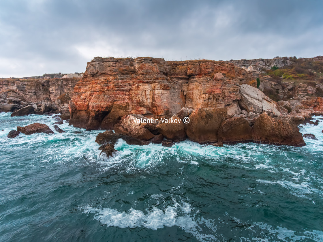 "Aerial view of rocky coastline with crashing waves." stock image