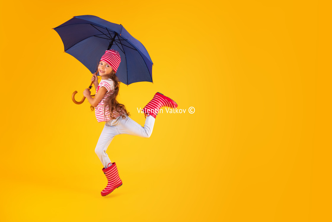 "Happy emotional girl laughing with umbrella on colored yellow ba" stock image