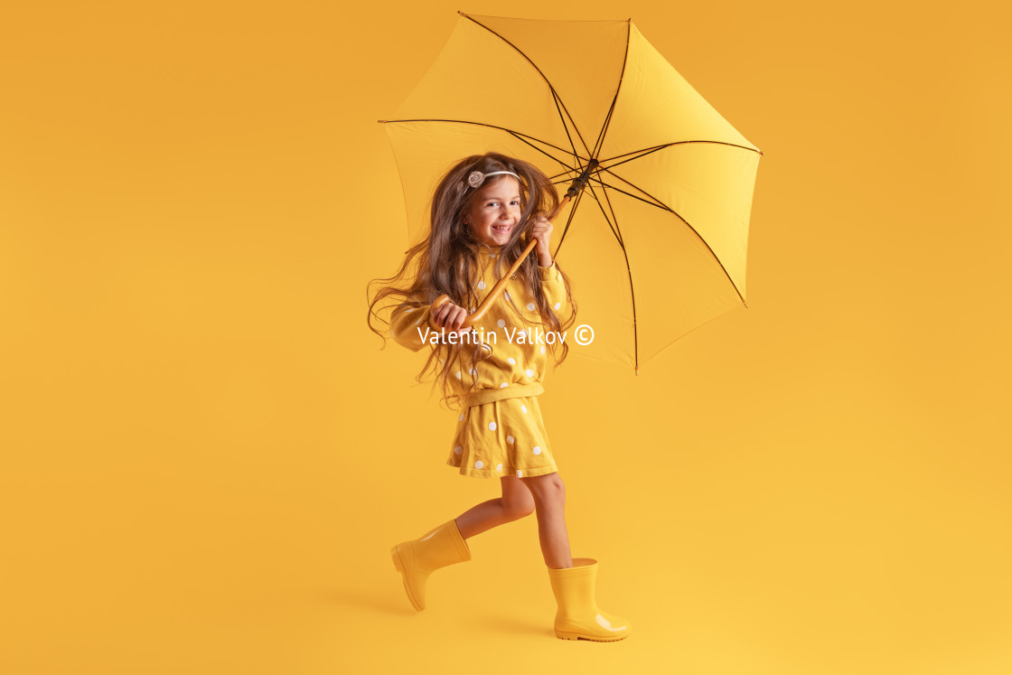 "Happy emotional girl laughing with umbrella on colored yellow ba" stock image