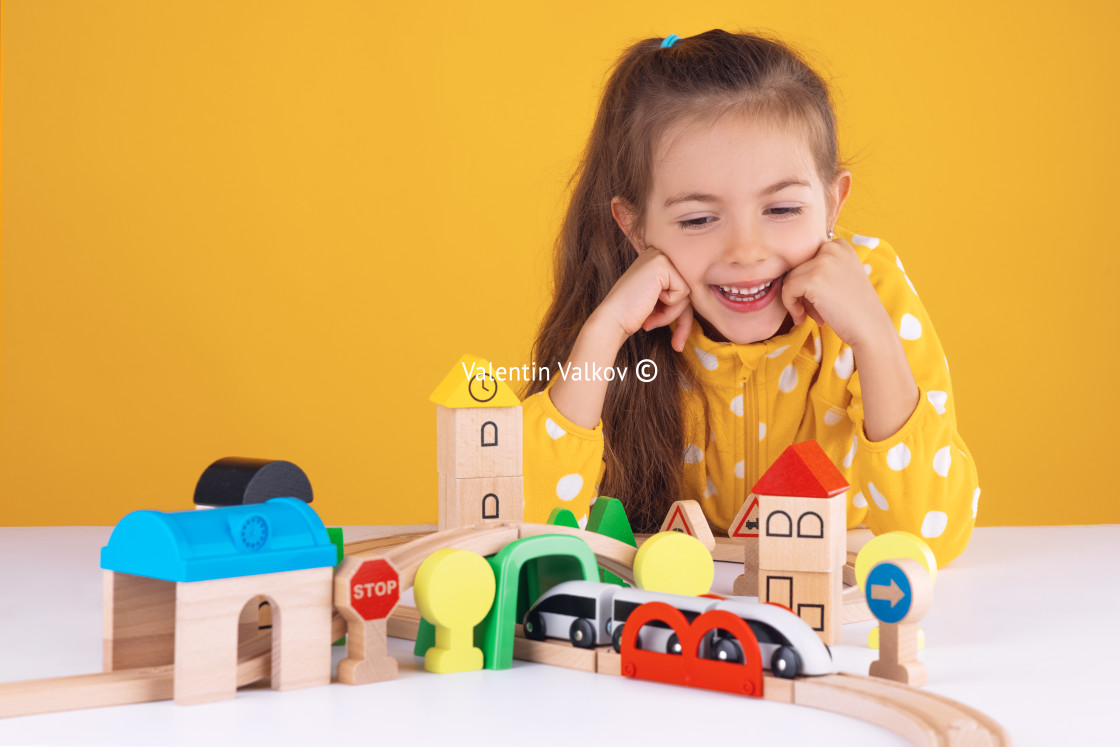 "Cute kid, little girl playing with wooden toys train and railway" stock image