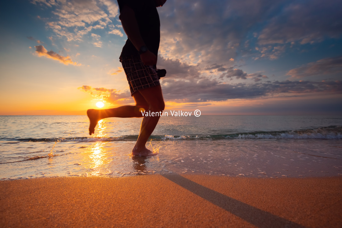 "Silhouette of running man on the beach, sunrise shot." stock image