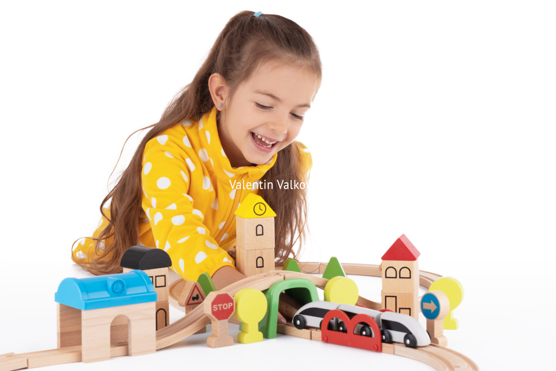 "Cute kid, little girl playing with wooden toys train and railway" stock image