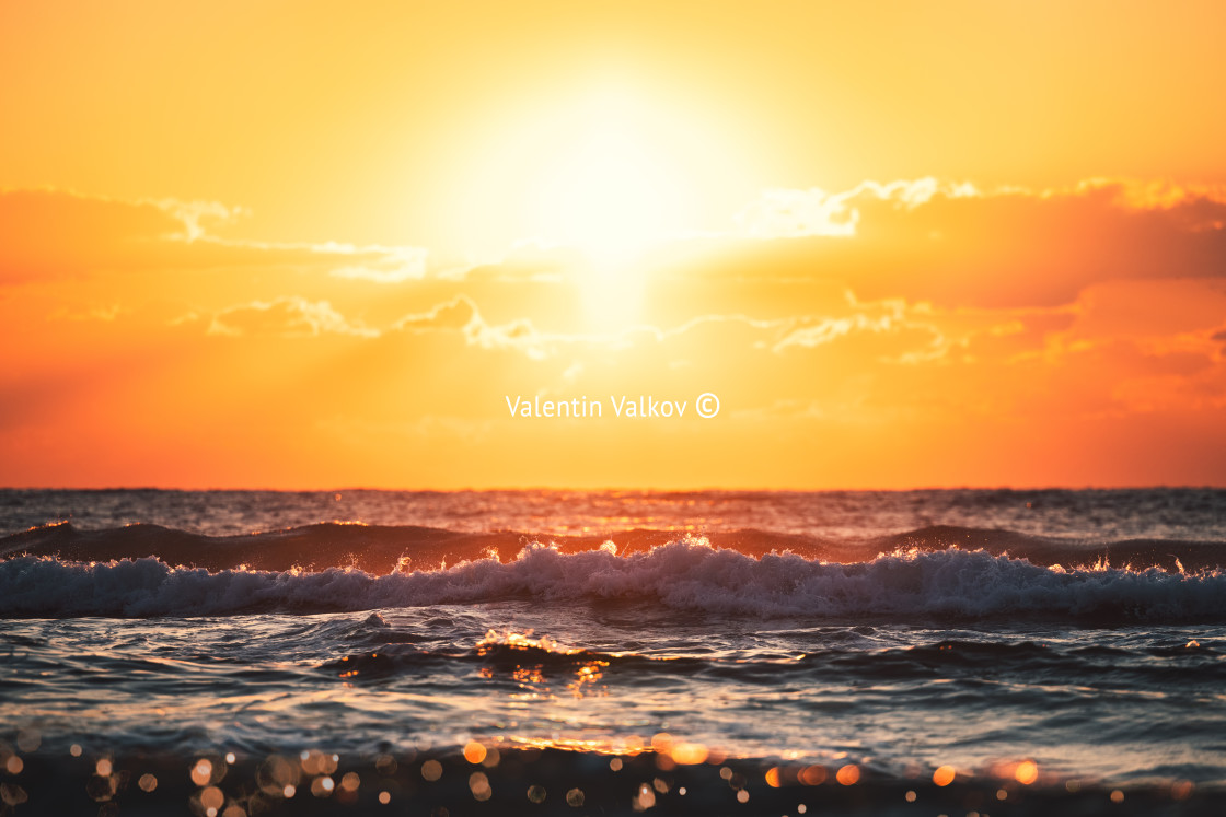 "Splashing wave and sunrise beach" stock image