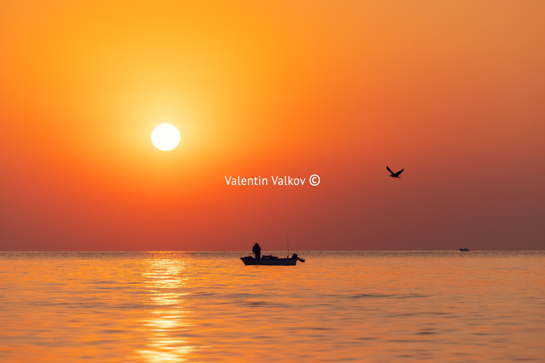 "Silhouette of fisherman in a boat and norning sunrise" stock image