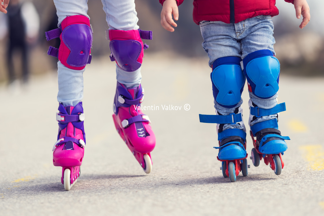 "Kids boy and girl having fun outdoor while riding roller skates." stock image