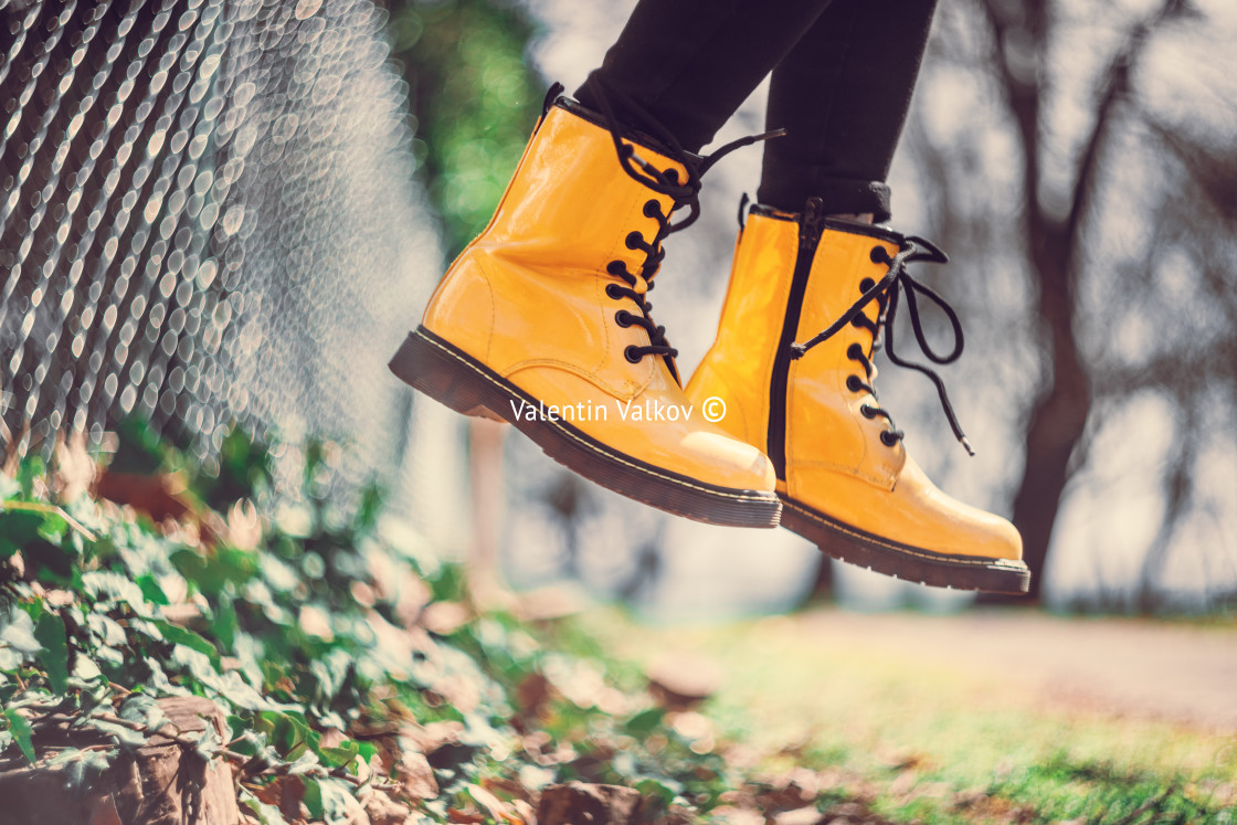 "Yellow boots of a jumping girl in green grass outdoor, defocus b" stock image