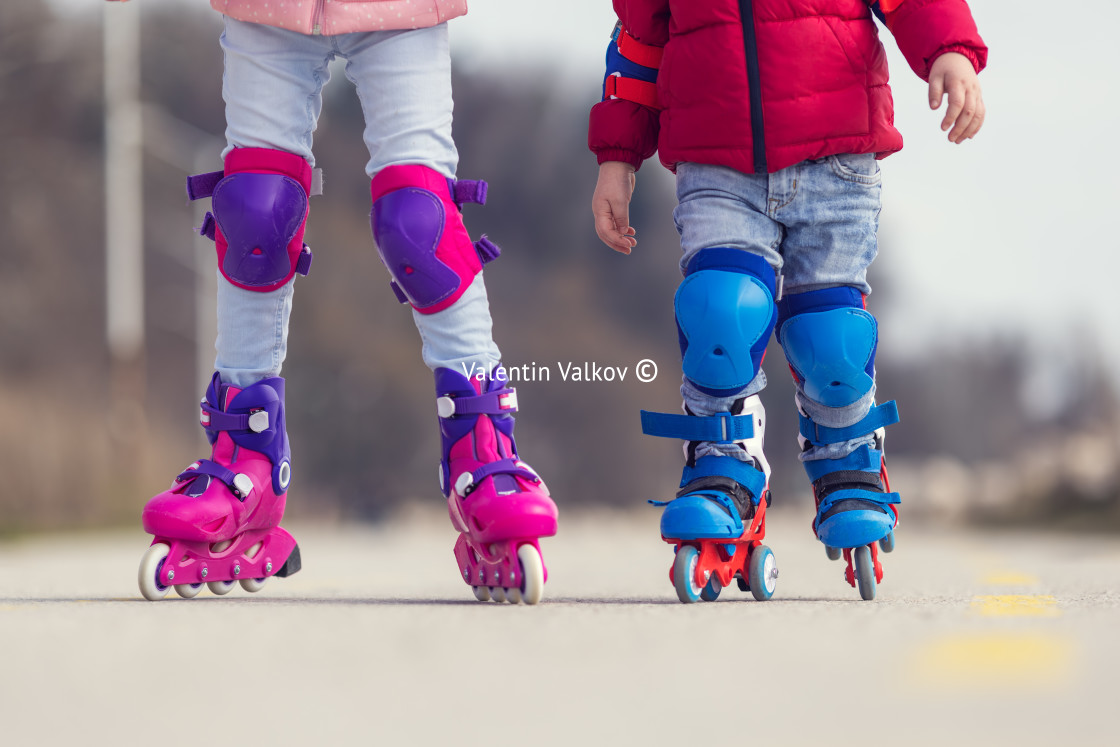 "Kids boy and girl having fun outdoor while riding roller skates." stock image