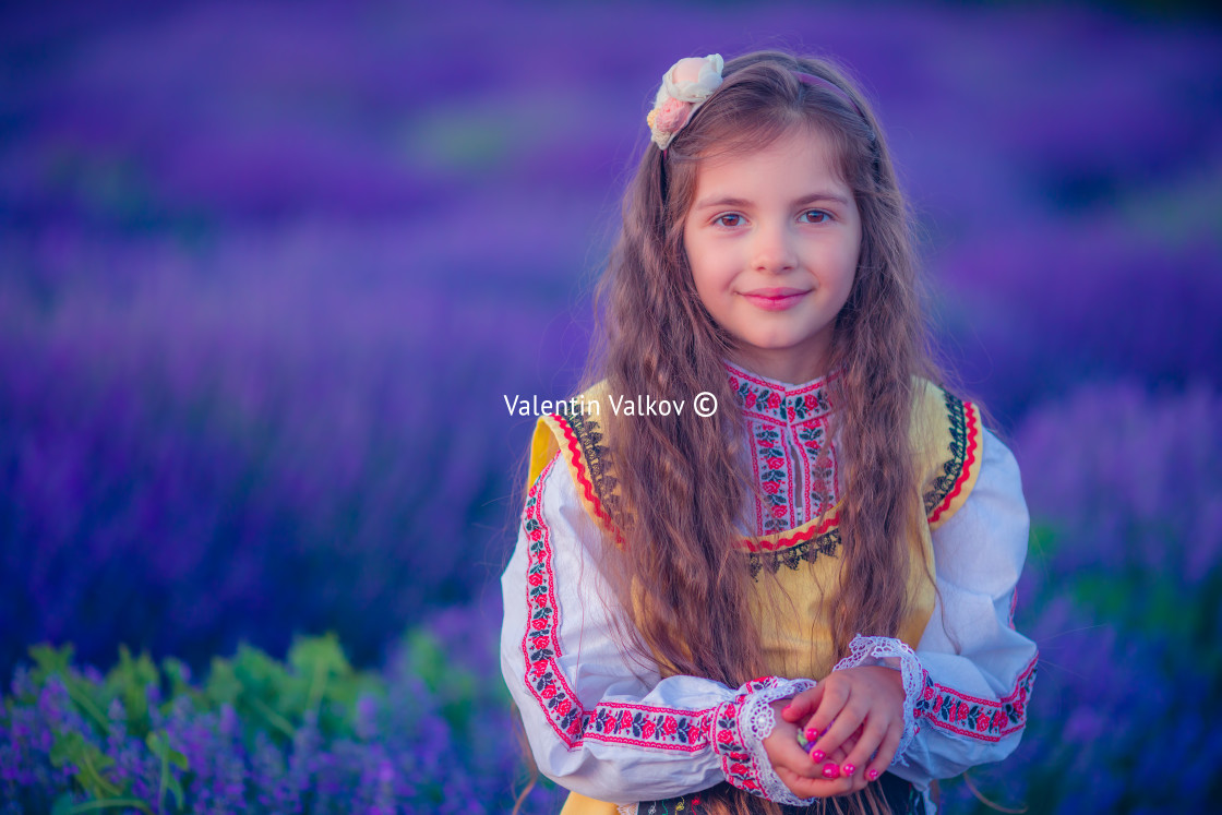 "Happy little girl with folklore dress enjoying lavender field with bouque" stock image