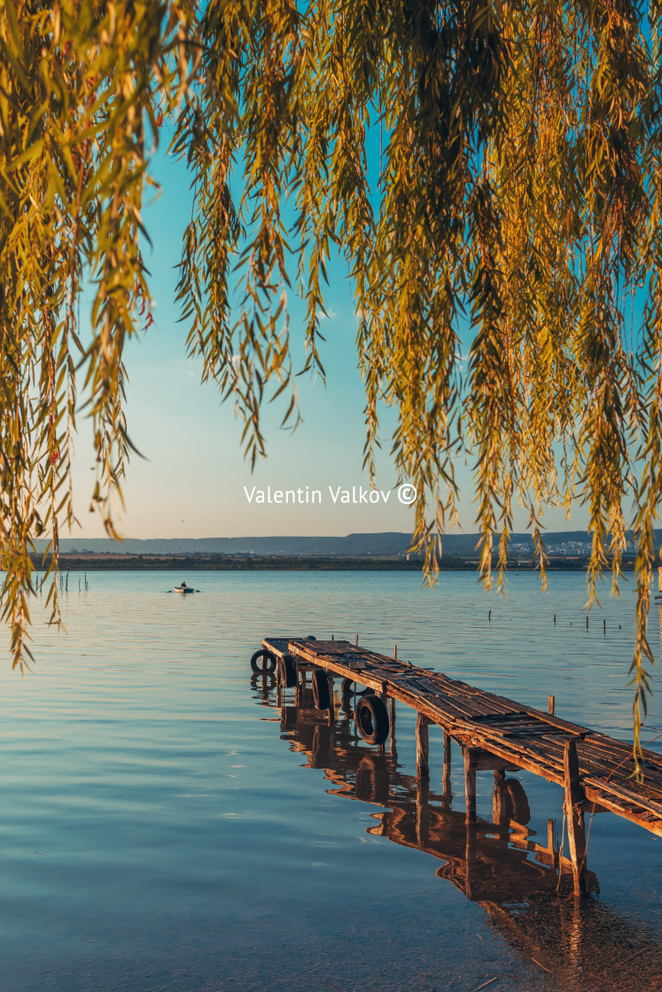 "Sunset over the sea lake and old wooden pier, romantic travel de" stock image